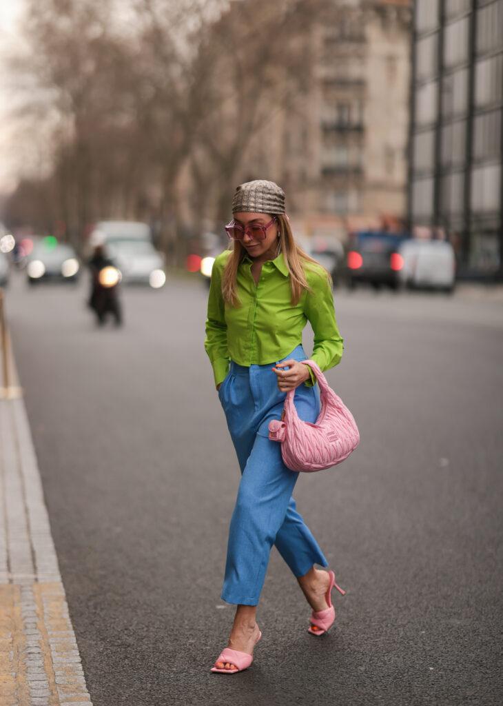 Mergina dėvinti žalius marškinius, mėlynas kelnes ir rožines šlepetes