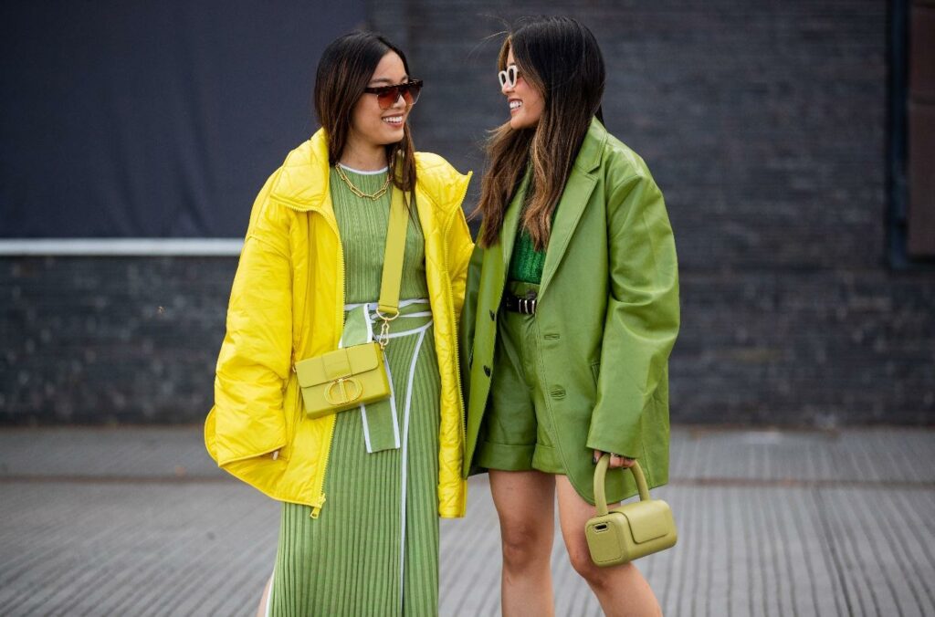 Dvi merginos, dėvinčios žalios ir geltonos spalvų drabužius