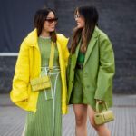 Dvi merginos, dėvinčios žalios ir geltonos spalvų drabužius