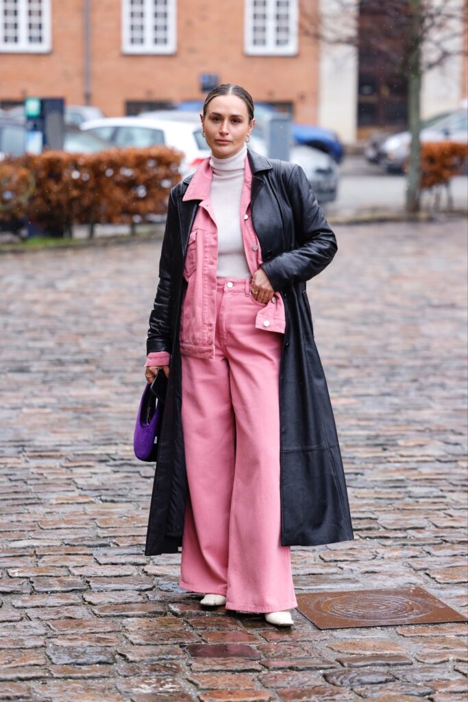 Nuomonės formuotoja su juodu Matricos paltu ir rožine Gestuz džinsine apranga