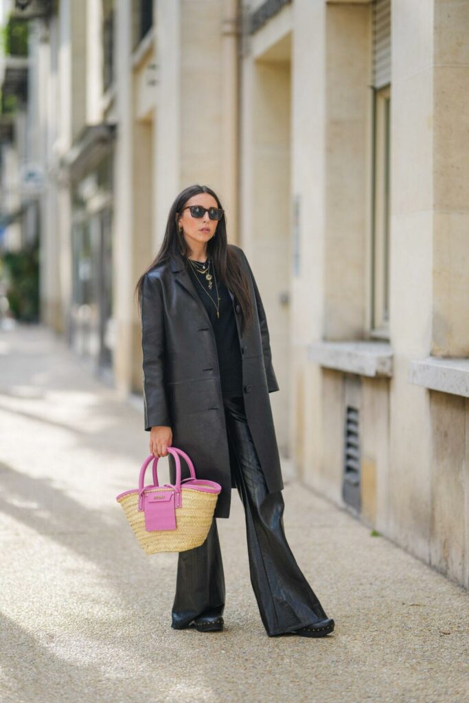 Moteris, dėvinti juodus drabužius, laiko pintą XXL dydžio krepšį