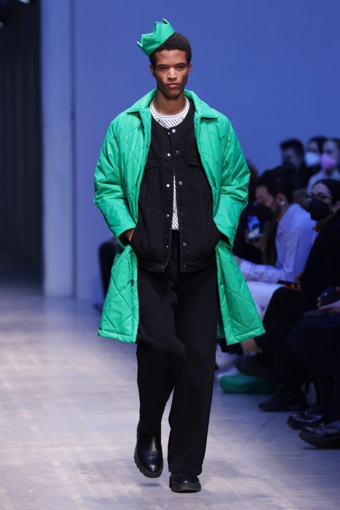 Modelis, dėvintis žalią pūkinį paltą
