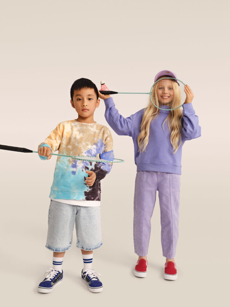 Mergaitė ir berniukas, laikantys badmintono raketes