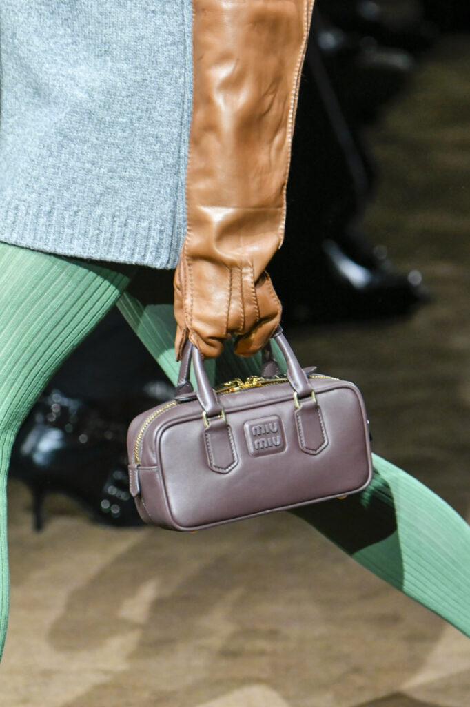 modelis, laikanti stačiakampę rankinę ant Miu Miu FW 2024/2025 podiumo